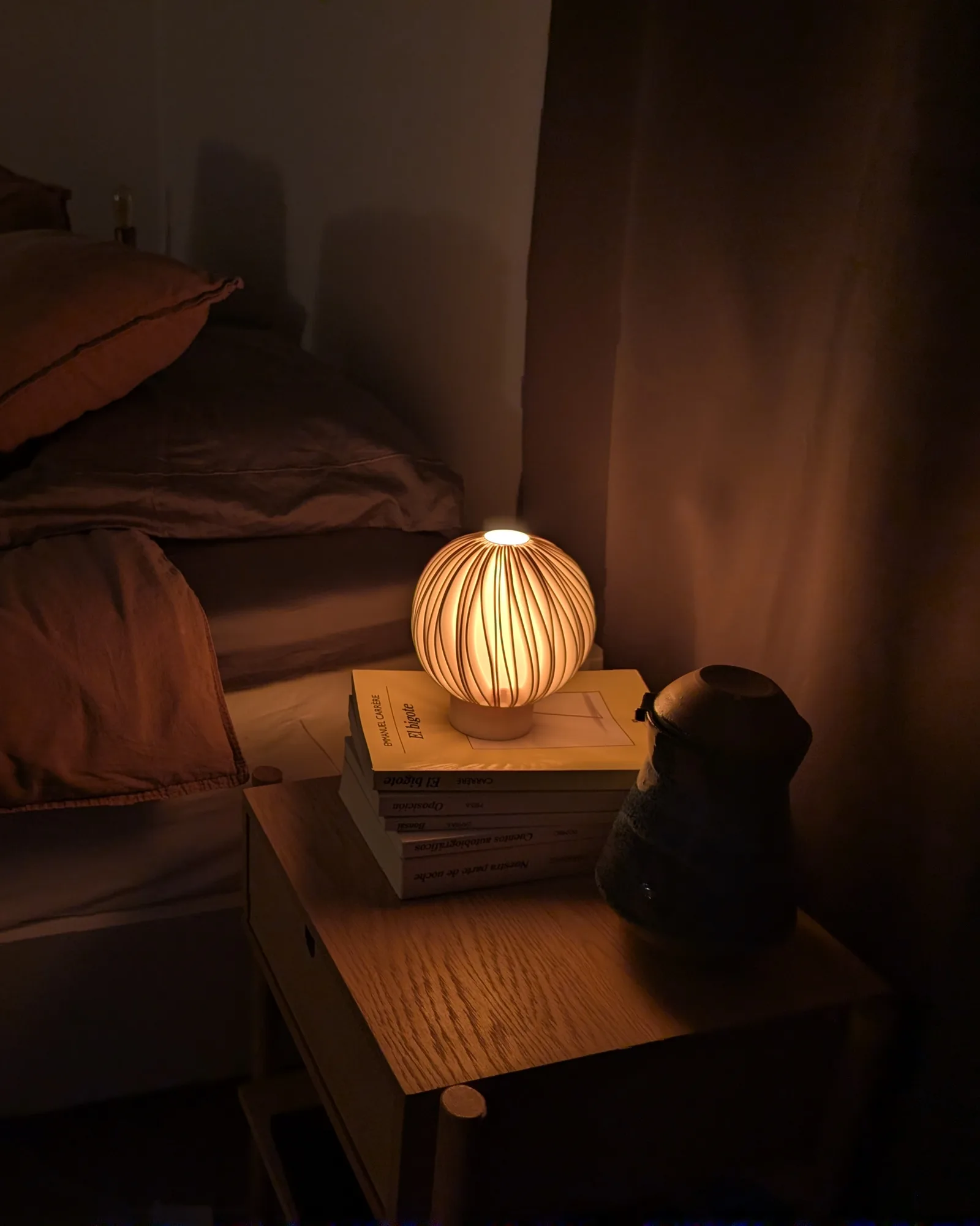 Small Rima lamp casting a warm bedside glow